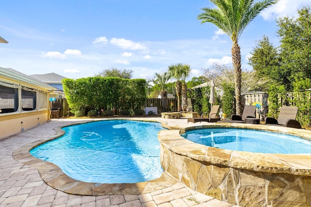 view of pool with a patio area and an in ground hot tub