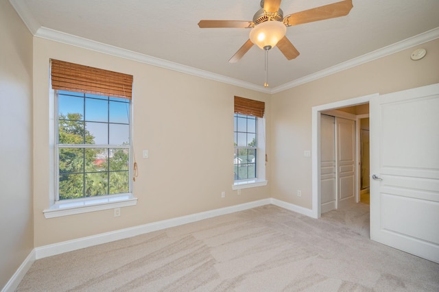 unfurnished bedroom featuring light carpet, a closet, ceiling fan, and crown molding