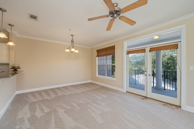 empty room with light carpet, ceiling fan with notable chandelier, and ornamental molding