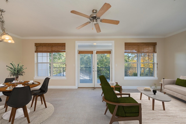 carpeted living room with ceiling fan, crown molding, and french doors