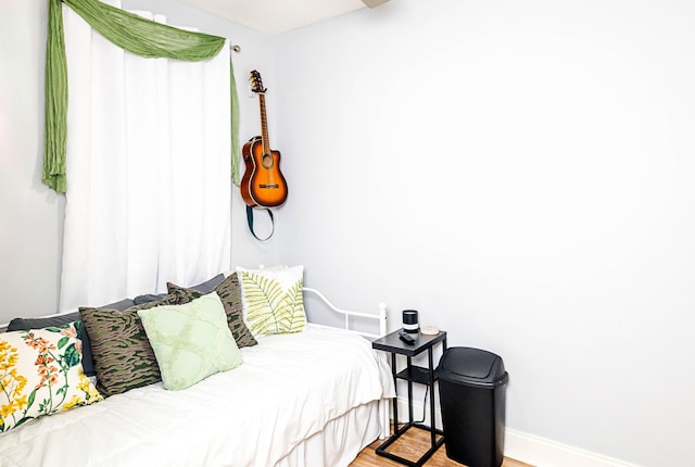 bedroom with baseboards and wood finished floors