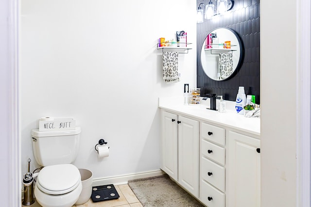 bathroom featuring toilet, tile patterned flooring, vanity, and baseboards