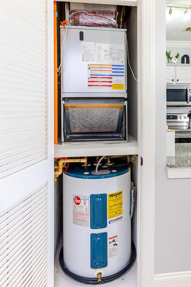 utility room with heating unit and water heater