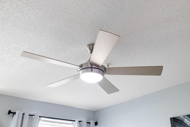 interior details with a ceiling fan and a textured ceiling