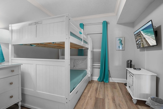 bedroom with wood-type flooring and crown molding