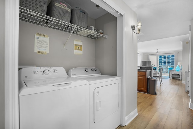 clothes washing area with light hardwood / wood-style floors and independent washer and dryer