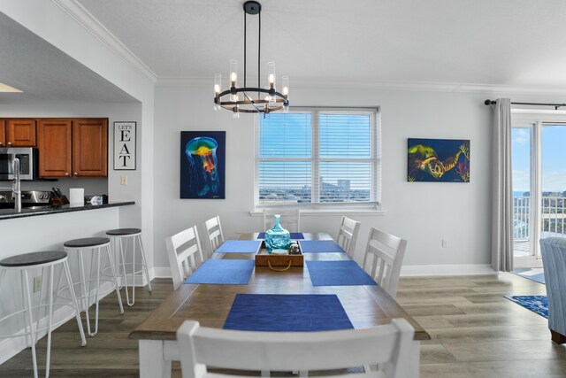 dining space featuring light hardwood / wood-style flooring, an inviting chandelier, and crown molding