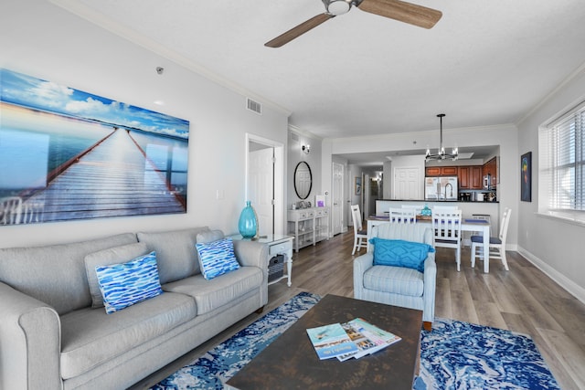 living room featuring light hardwood / wood-style floors, ceiling fan, and ornamental molding