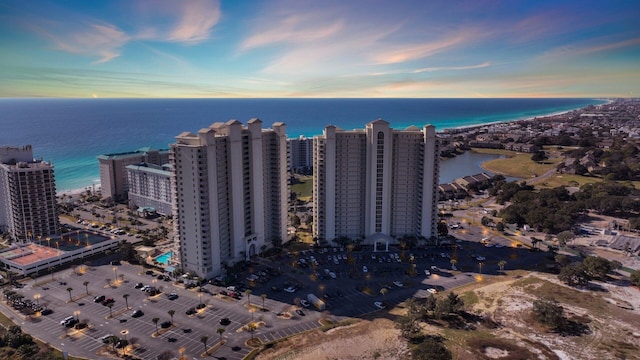 aerial view at dusk featuring a water view