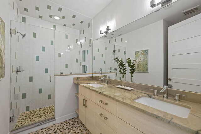 bathroom featuring tile patterned flooring, vanity, and a shower with shower door