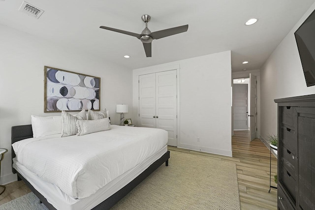 bedroom featuring a closet, light hardwood / wood-style floors, and ceiling fan