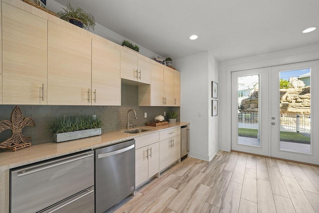 kitchen with dishwasher, backsplash, french doors, sink, and light wood-type flooring