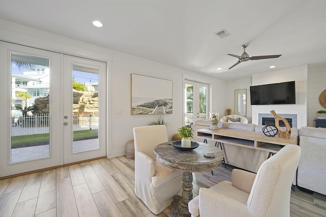 dining space with french doors, light wood-type flooring, and ceiling fan