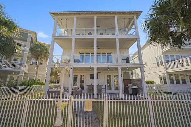 coastal inspired home with ceiling fan, a balcony, and french doors