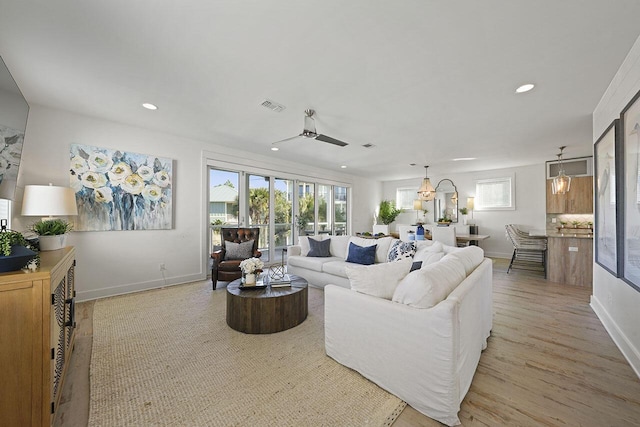 living room featuring ceiling fan and light hardwood / wood-style floors