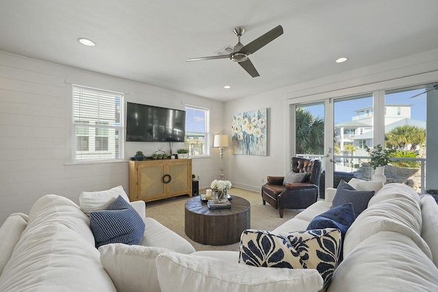 living room with carpet flooring, ceiling fan, and plenty of natural light