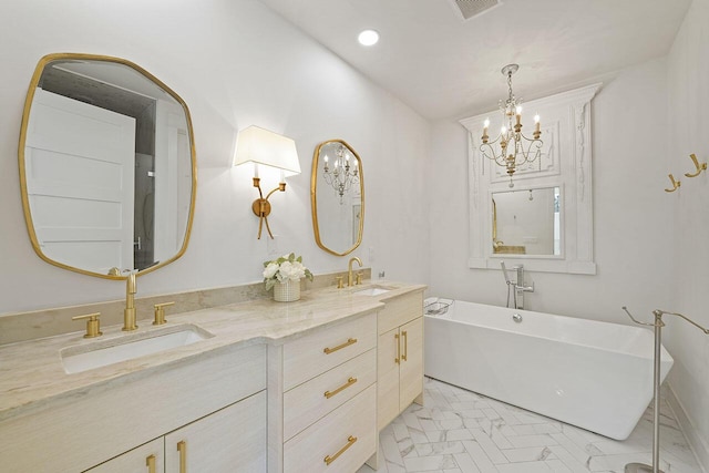 bathroom with a bathtub, vanity, and an inviting chandelier