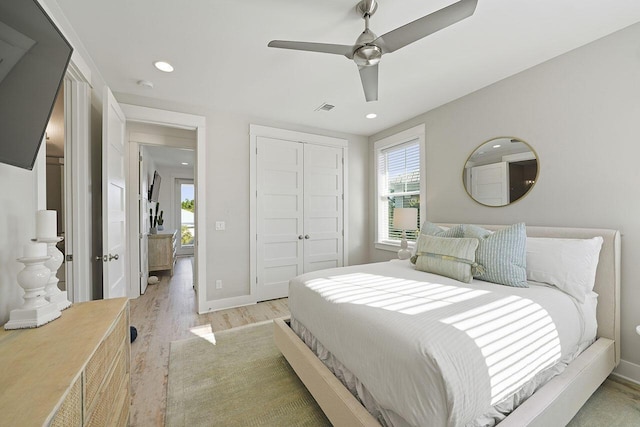 bedroom with a closet, ceiling fan, and light hardwood / wood-style flooring