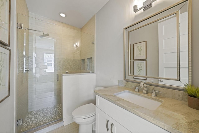 bathroom featuring vanity, toilet, and an enclosed shower