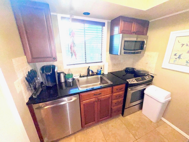 kitchen featuring backsplash, appliances with stainless steel finishes, sink, and light tile patterned floors