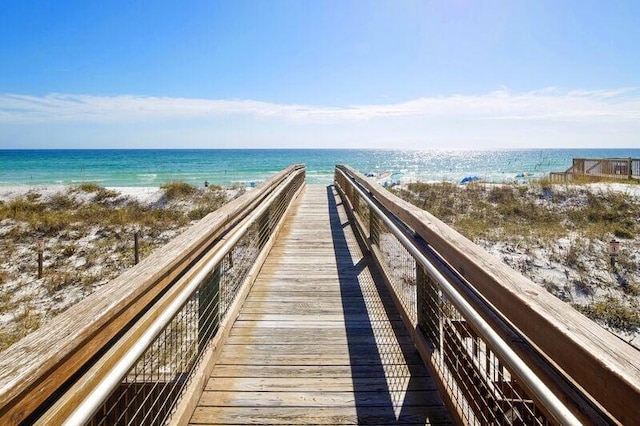 view of property's community with a water view and a beach view