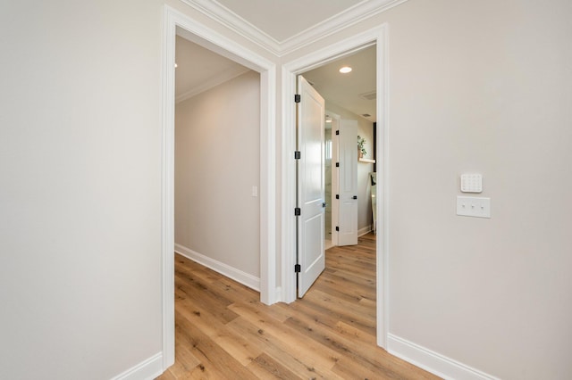 hall with light hardwood / wood-style flooring and crown molding