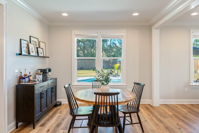 dining room featuring crown molding, plenty of natural light, and light hardwood / wood-style floors