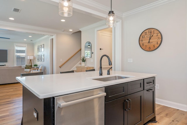 kitchen with sink, an island with sink, stainless steel dishwasher, and ornamental molding