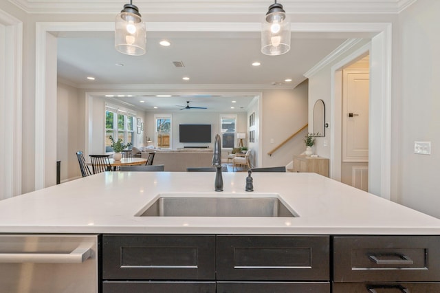 kitchen with pendant lighting, stainless steel dishwasher, ornamental molding, and sink