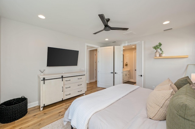 bedroom featuring ensuite bath, ceiling fan, and light hardwood / wood-style flooring