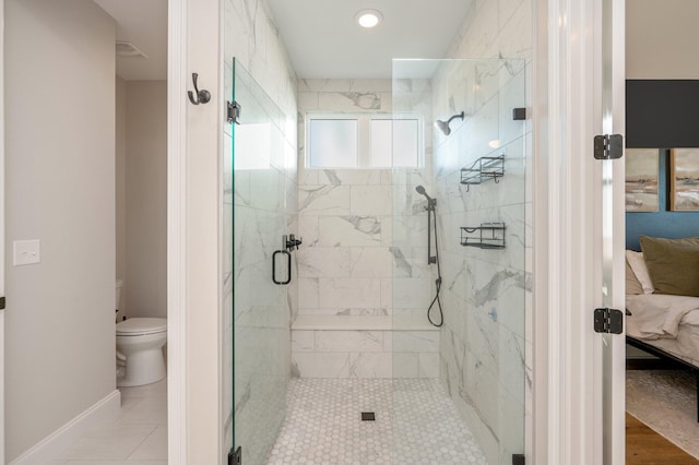 bathroom with tile patterned flooring, a shower with door, and toilet