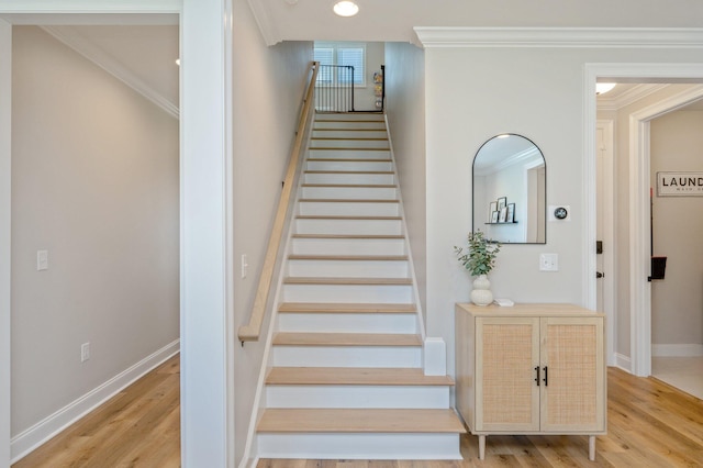 staircase with crown molding and wood-type flooring