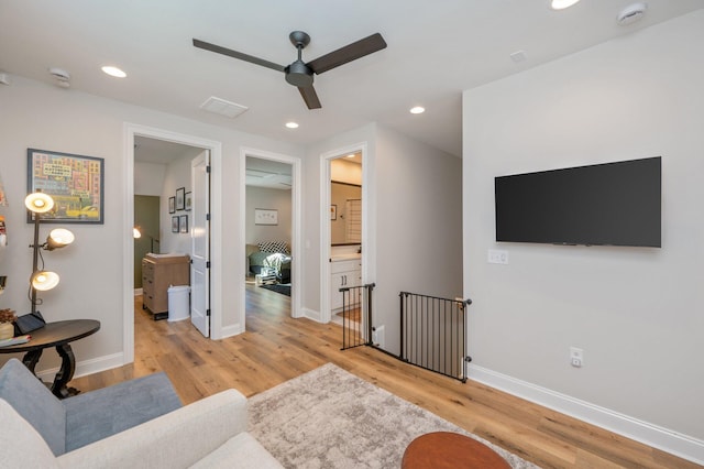 living room featuring ceiling fan and light hardwood / wood-style flooring