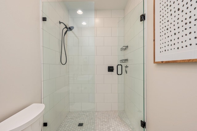 bathroom with toilet and a shower with door