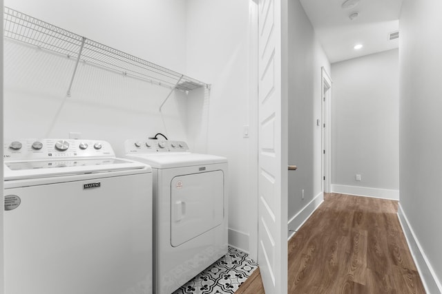 washroom with hardwood / wood-style floors and independent washer and dryer