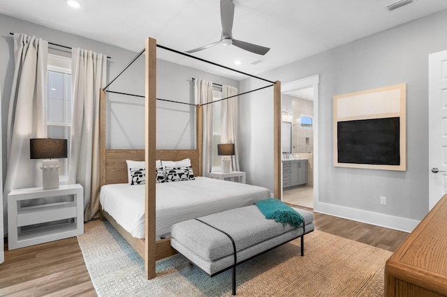 bedroom with hardwood / wood-style floors, ceiling fan, and ensuite bath