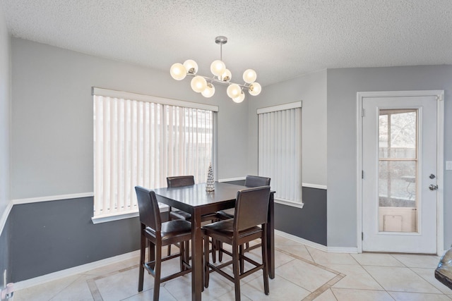 dining area with light tile patterned flooring, a textured ceiling, and a chandelier