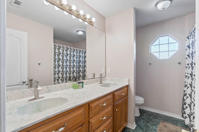 bathroom with vanity, a textured ceiling, and toilet