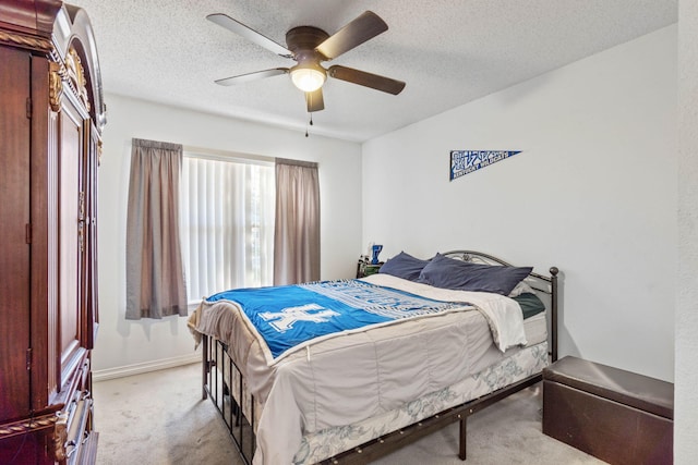 carpeted bedroom featuring ceiling fan and a textured ceiling