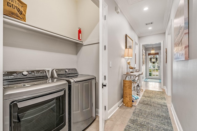 laundry room featuring separate washer and dryer, crown molding, and light tile patterned flooring