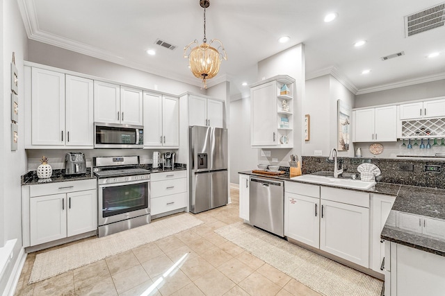 kitchen featuring white cabinets, sink, light tile patterned floors, appliances with stainless steel finishes, and decorative light fixtures