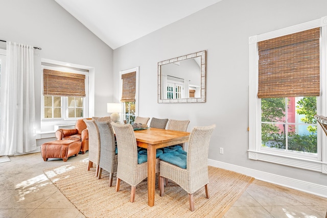 dining space with light tile patterned floors and high vaulted ceiling