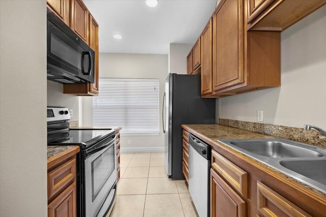 kitchen with light tile patterned flooring, stainless steel appliances, and sink