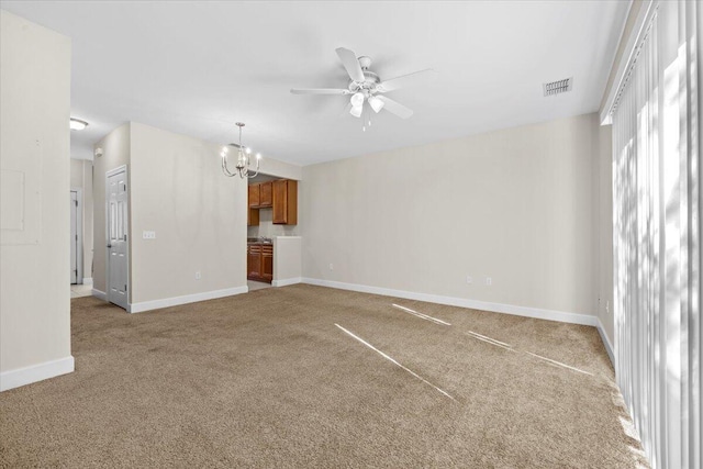 unfurnished living room with carpet and ceiling fan with notable chandelier