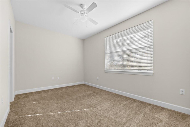 carpeted spare room featuring ceiling fan