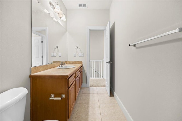 bathroom with tile patterned flooring, vanity, and toilet