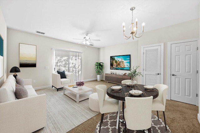 living room with ceiling fan with notable chandelier and light colored carpet