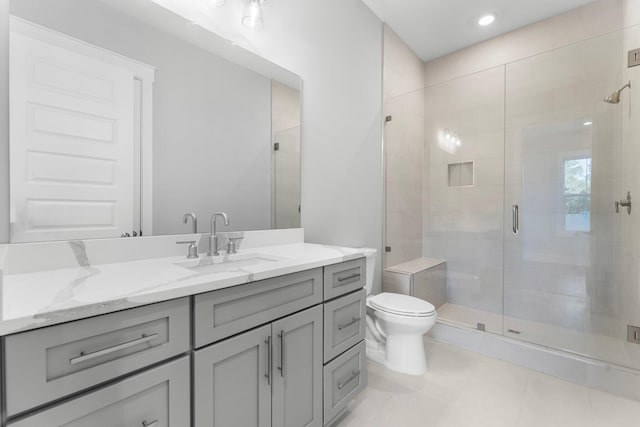 bathroom with vanity, toilet, and a shower with door