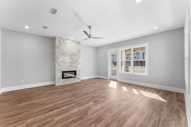 unfurnished living room with ceiling fan, a fireplace, and hardwood / wood-style floors