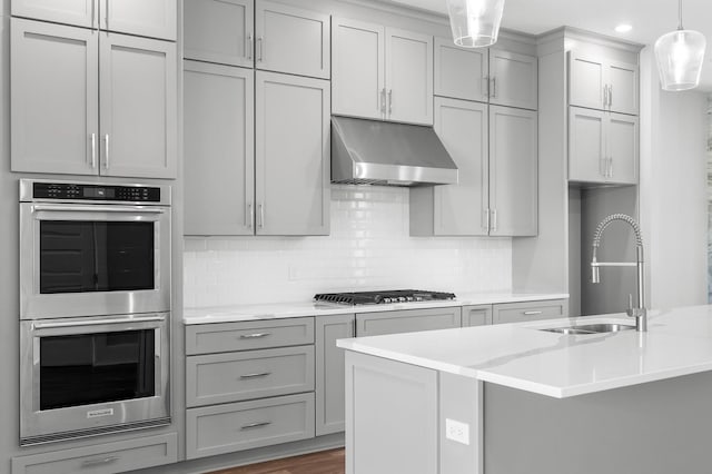 kitchen with ventilation hood, decorative light fixtures, gray cabinets, and appliances with stainless steel finishes